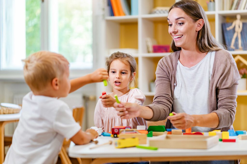 Eine junge Frau macht ein FSJ im Kindergarten und beschäftigt sich mit Kindern.