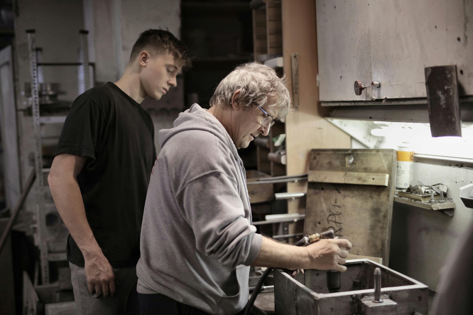 Ein Auszubildender beobachtet seinen Ausbilder bei der Arbeit in seiner Ausbildung.