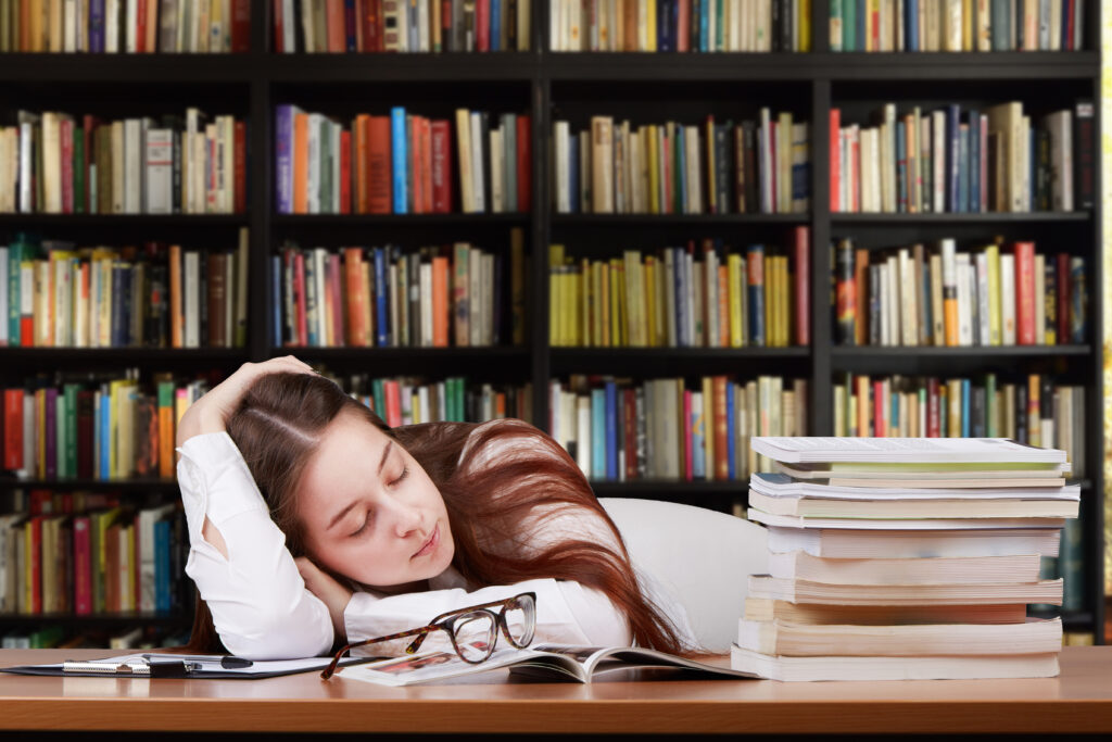 Studentin schläft am Schreibtisch.